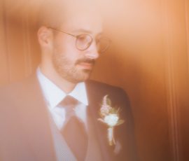 Noivo de fato escuro e boutonnière aguarda com serenidade, fotografia de casamento por Humberto Barbosa em Santa Maria da Feira