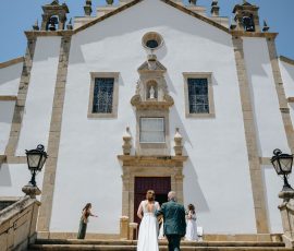 Noivos sobem escadaria rumo à igreja em dia de casamento captado por Humberto Barbosa em Santa Maria da Feira