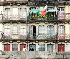 Noivos posam em varanda de edifício histórico — fotografia de casamento no Porto por Humberto Barbosa